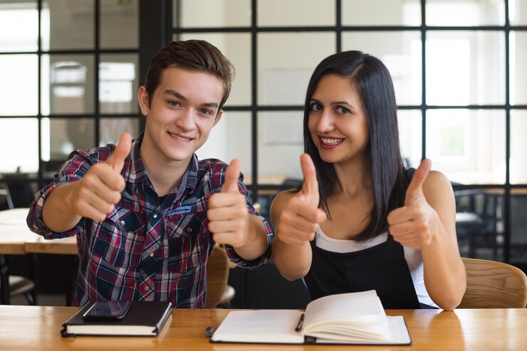 Happy driving school students celebrating success with thumbs up gesture